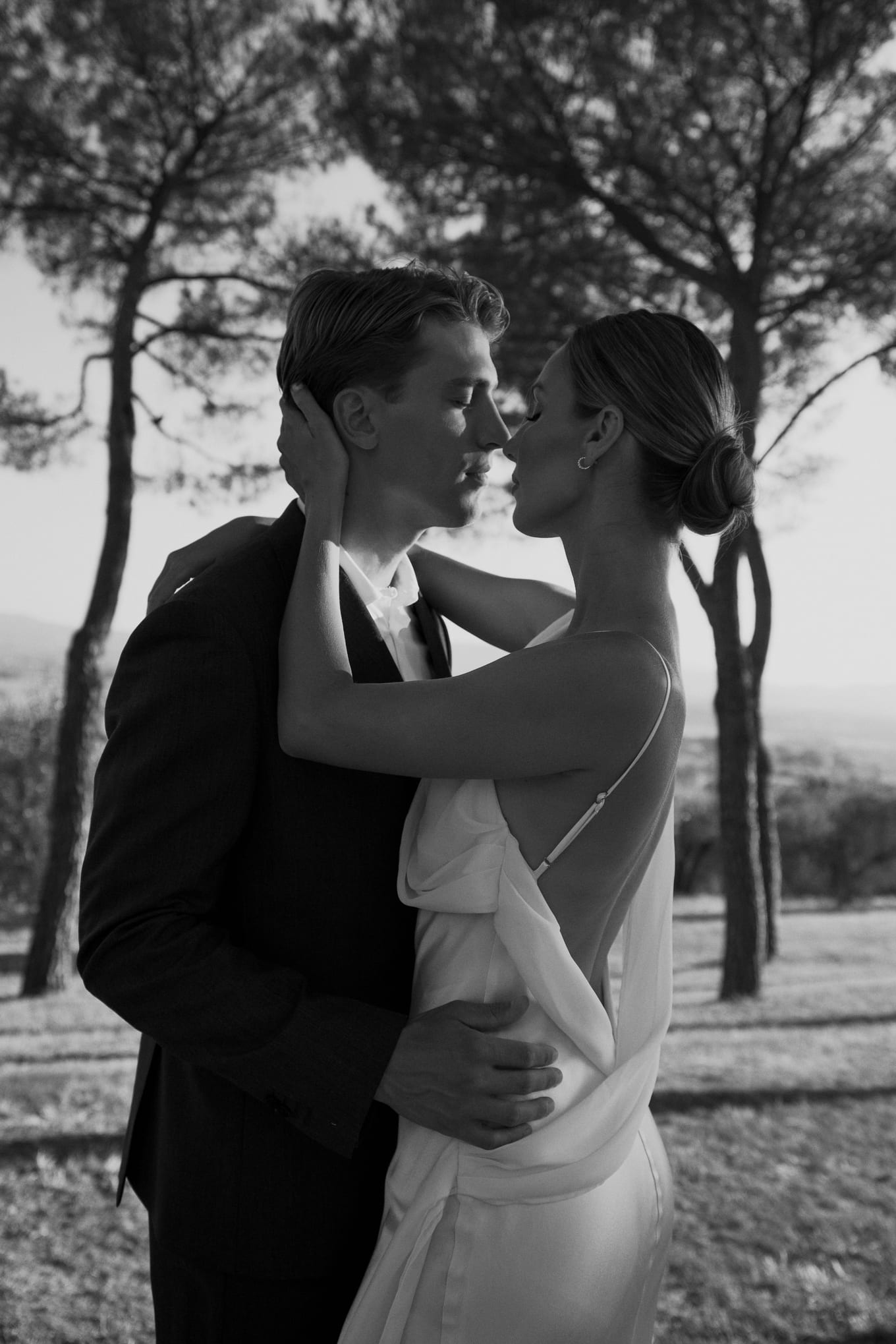 Black-and-white close shot of a woman cradling a man's head as their faces almost touch