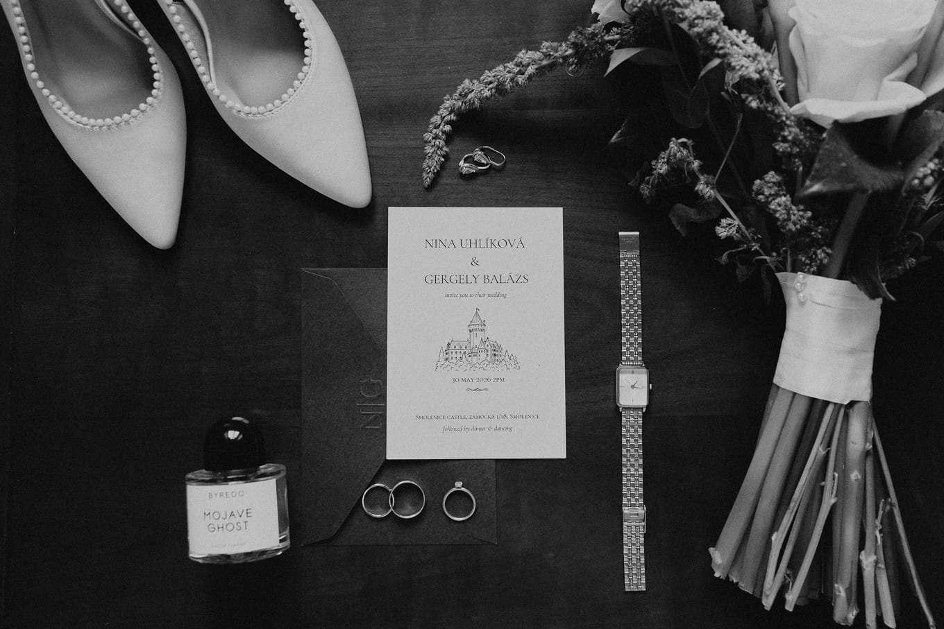 Flat lay of the bride's shoes, invitation, watch, rings and bouquet