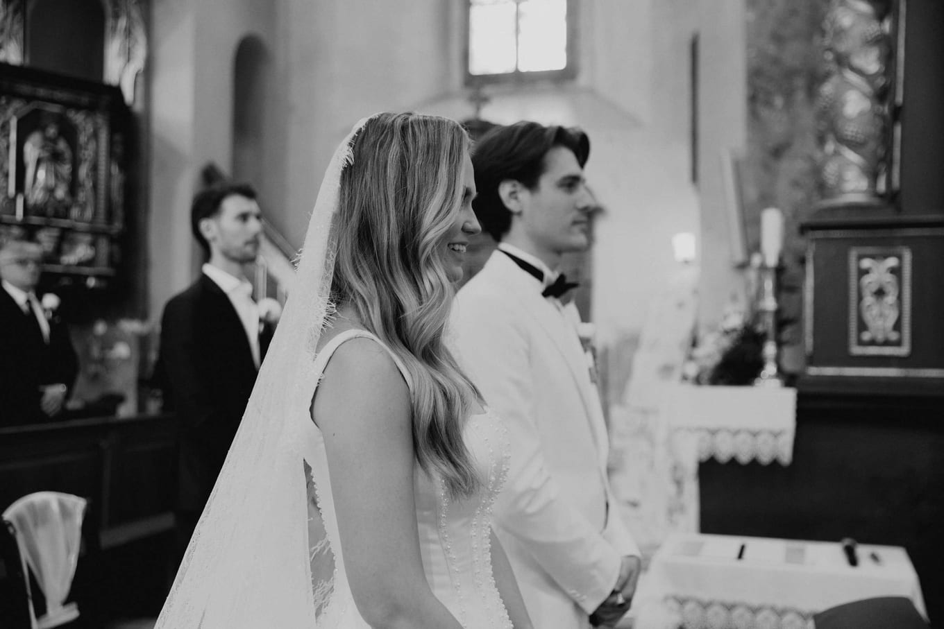 The couple side by side before the priest