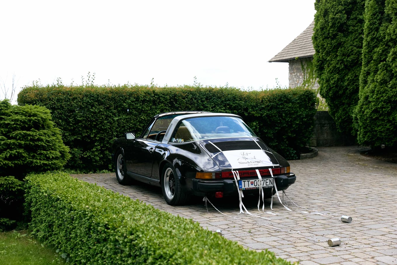 The decorated car parked beside the hedge