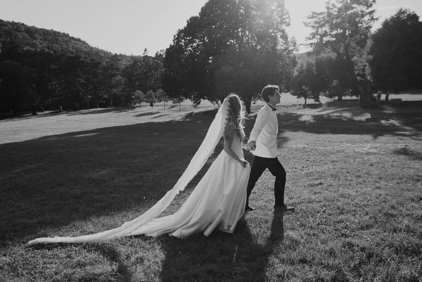 The groom leading the bride through the long light